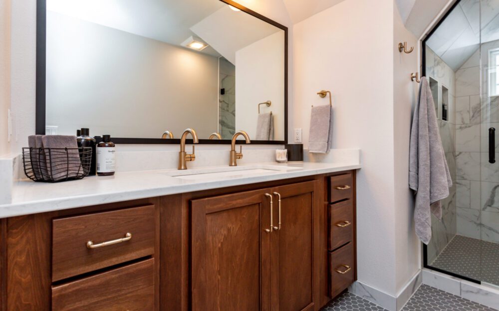 A double sink on a countertop with a large mirror