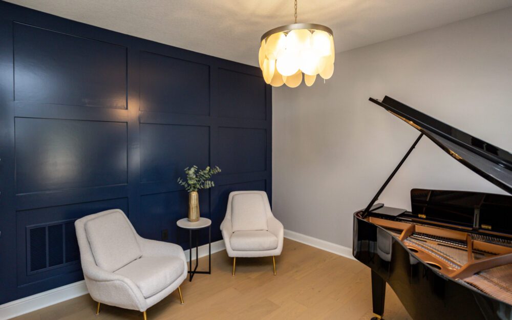 A piano room with two armchairs
