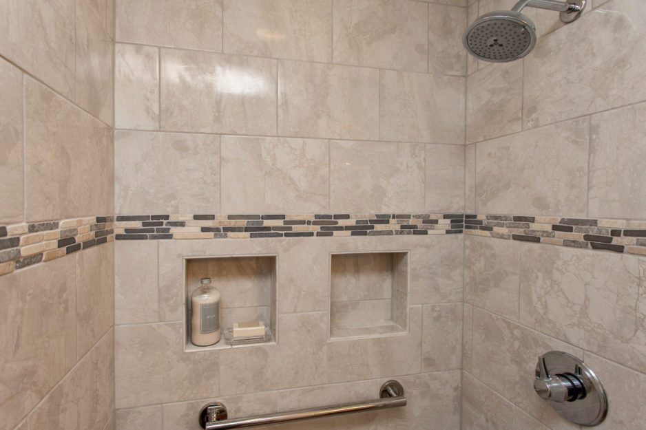 A light brown tiled shower area