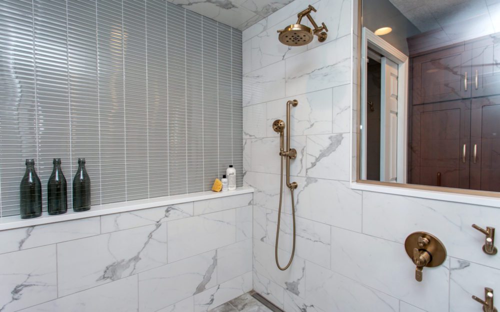 A shower area with bronze colored fixtures