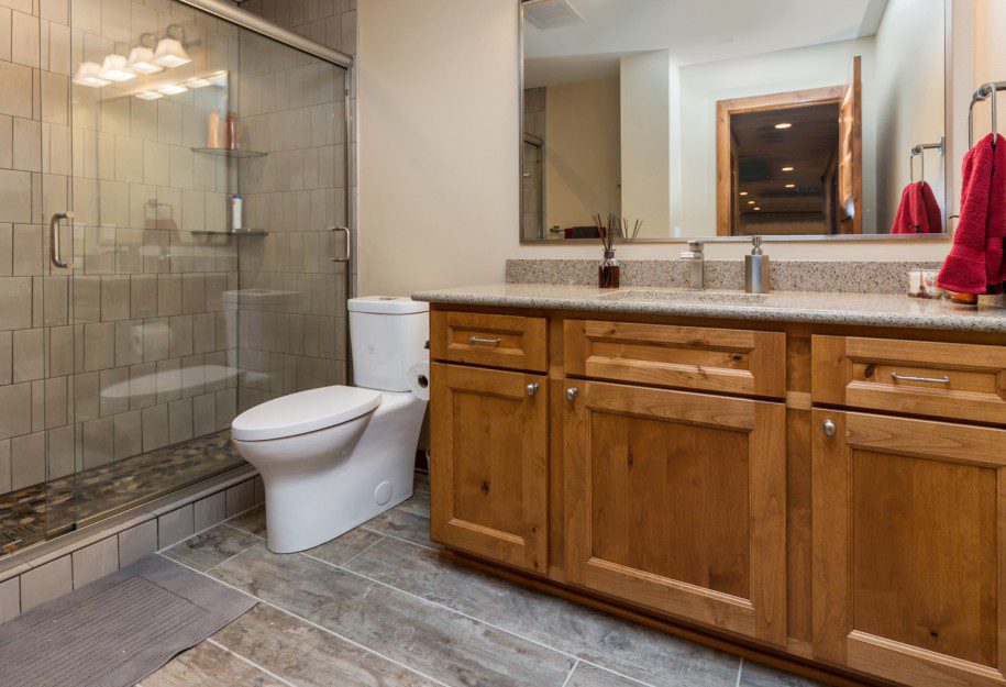 bathroom with rich brown cabinets and rectangle shower