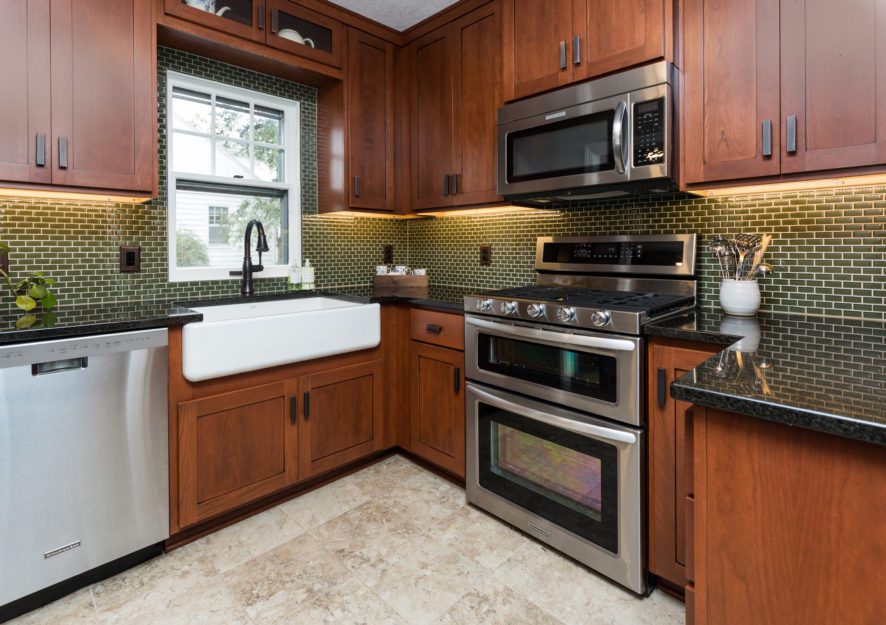 Dark brown cabinetry with dark green tiled wall
