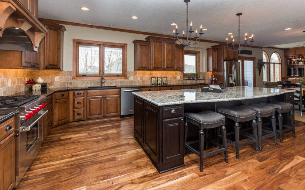 A kitchen with wood cabinetry and dark brown center table