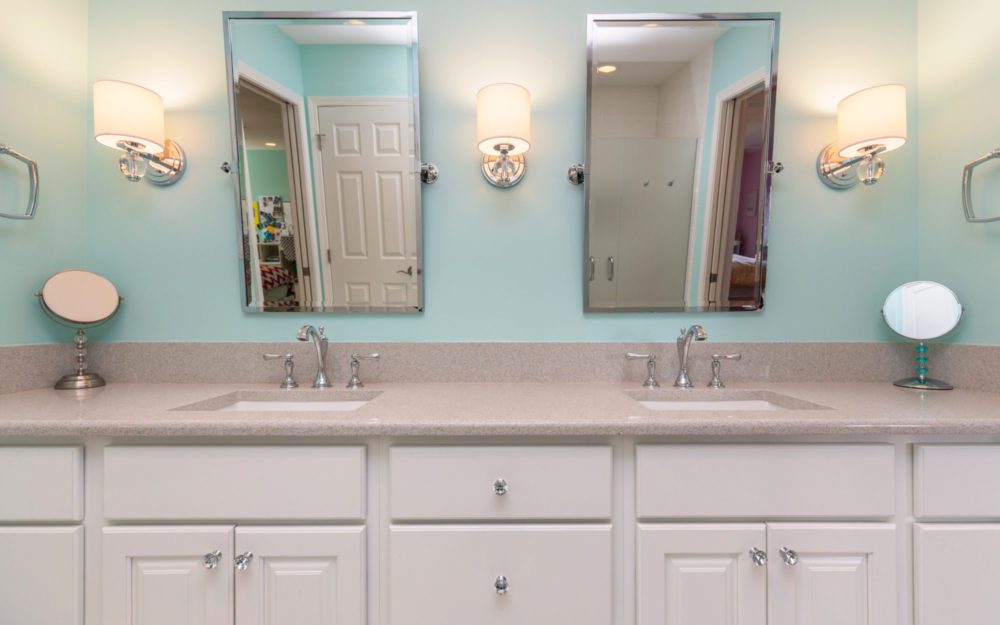 A bathroom countertop with double sinks  