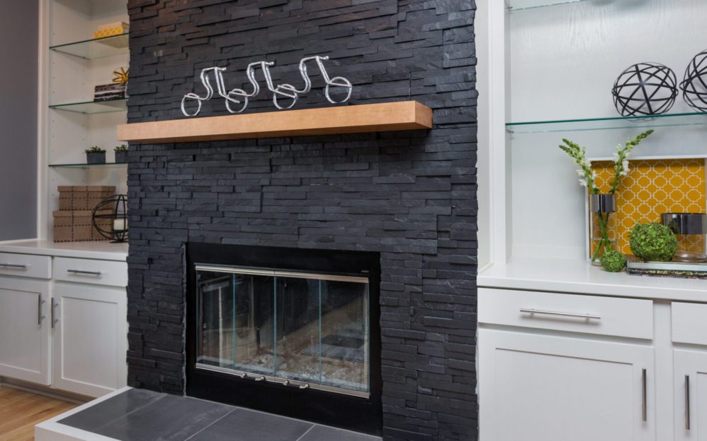 A fireplace with black brick walls